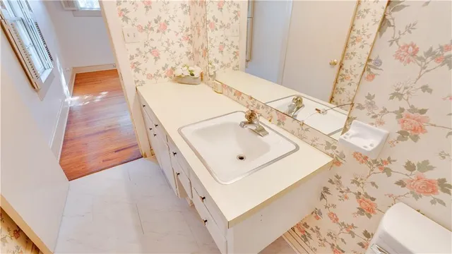 a bathroom with a sink and mirror with bathtub
