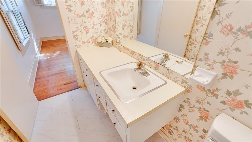 803 Forrest Avenue Tifton, GA 31794 - Photo 25 of 52 a bathroom with a sink and mirror with bathtub