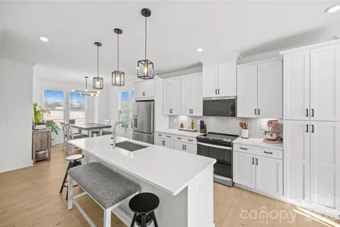 a kitchen with stainless steel appliances kitchen island granite countertop a stove a sink and a refrigerator