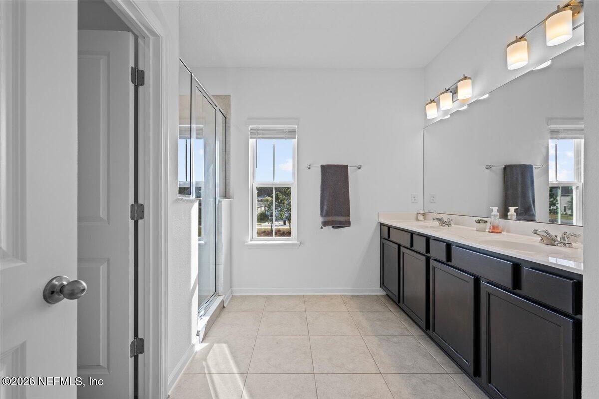 92 Patina Place St. Augustine, FL 32092 - Photo 19 of 26 a bathroom with a double vanity sink a mirror and a bathtub