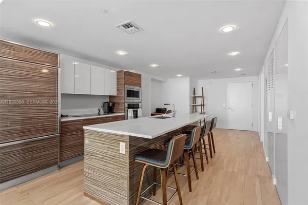 a large kitchen with kitchen island a sink table and chairs