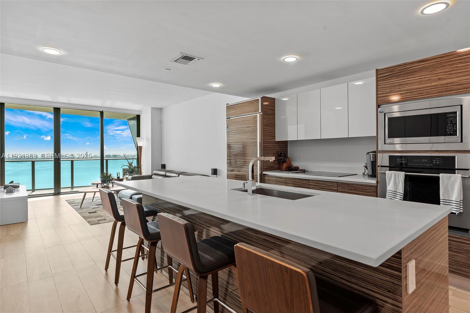 460 Northeast 28th Street, Unit 3903 Miami, FL 33137 - Photo 16 of 44 a kitchen with a table chairs microwave and cabinets