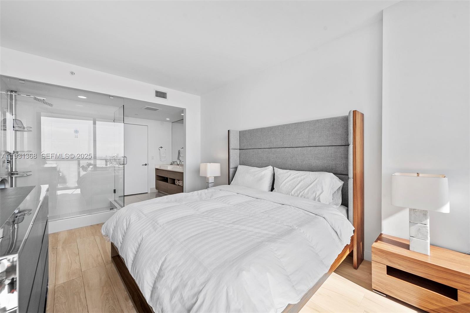 460 Northeast 28th Street, Unit 3903 Miami, FL 33137 - Photo 27 of 44 a large bed in a white room with a mirror