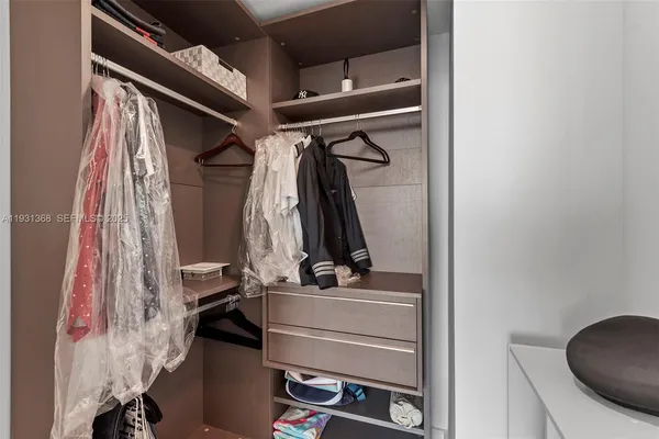 a view of walk in closet with clothes