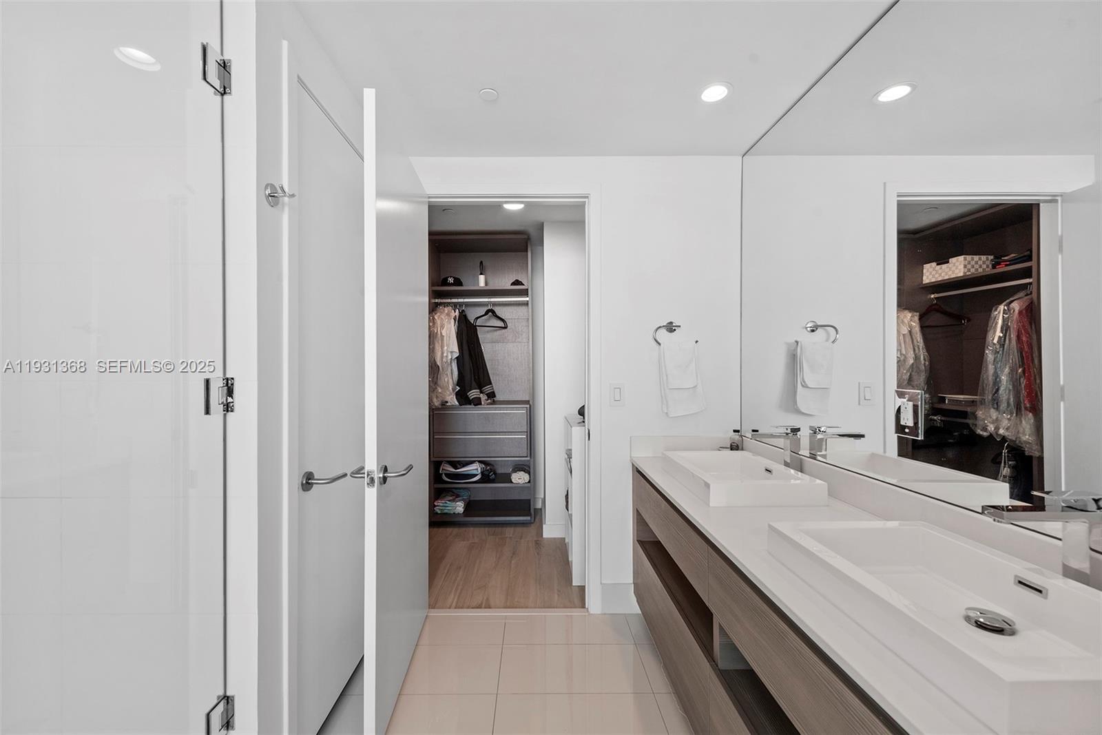 460 Northeast 28th Street, Unit 3903 Miami, FL 33137 - Photo 32 of 44 a bathroom with a double vanity sink a mirror and shower