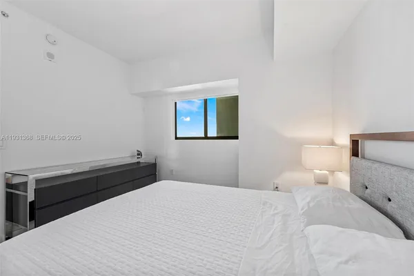 a bedroom with a bed and a night stand