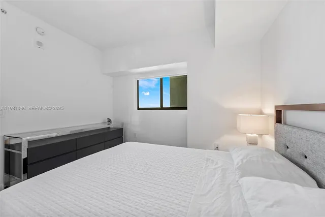 a bedroom with a bed and a night stand