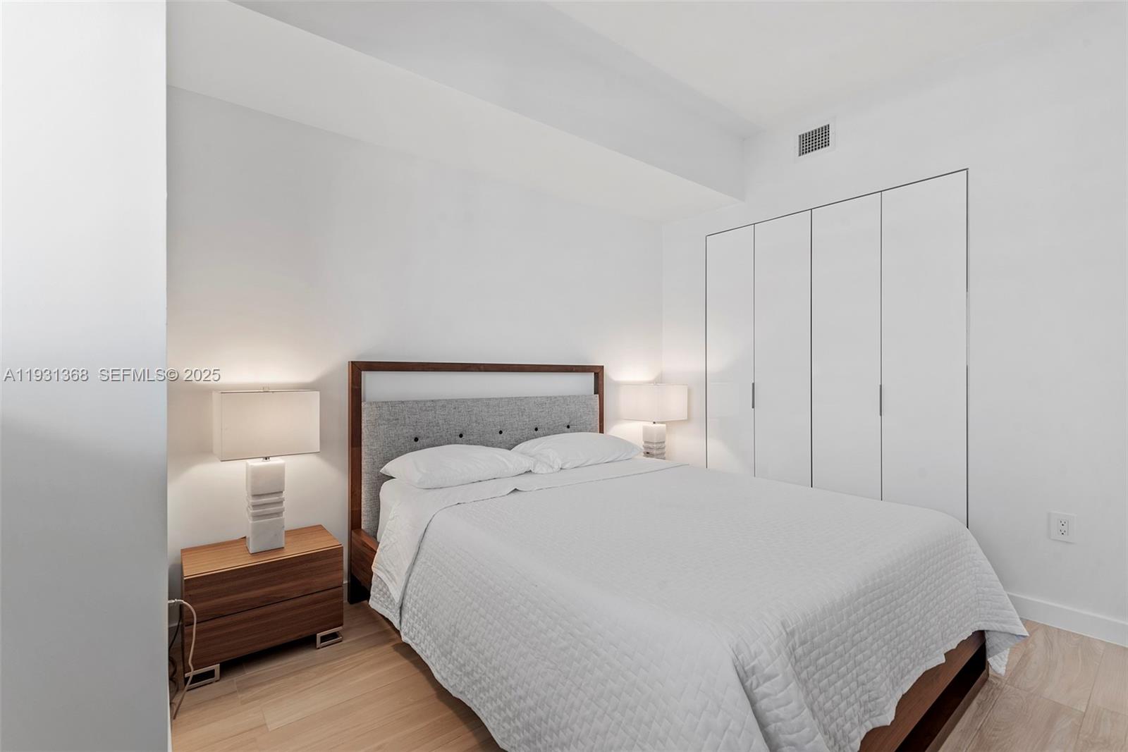 460 Northeast 28th Street, Unit 3903 Miami, FL 33137 - Photo 37 of 44 a bedroom with a bed and a night stand