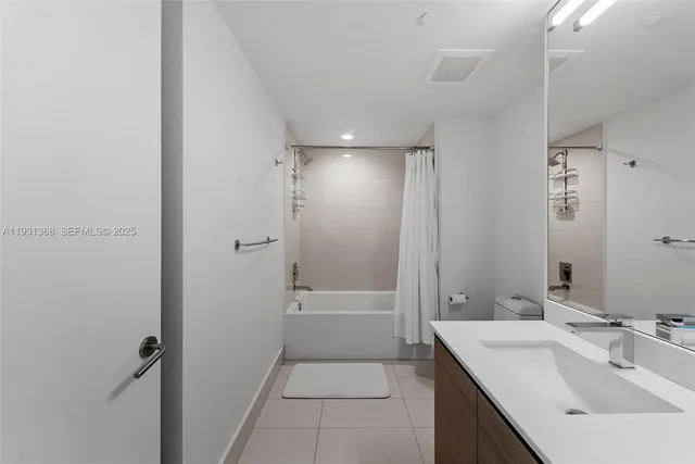 a bathroom with a bathtub shower sink vanity and a toilet