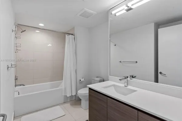 a bathroom with a bath tub sink mirror and a shower