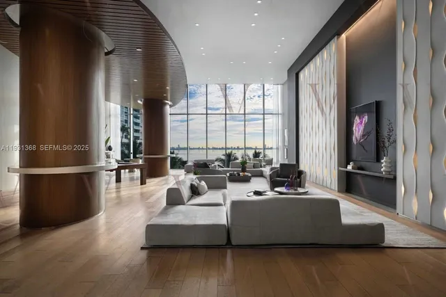 a living room with furniture wooden floor and a large window