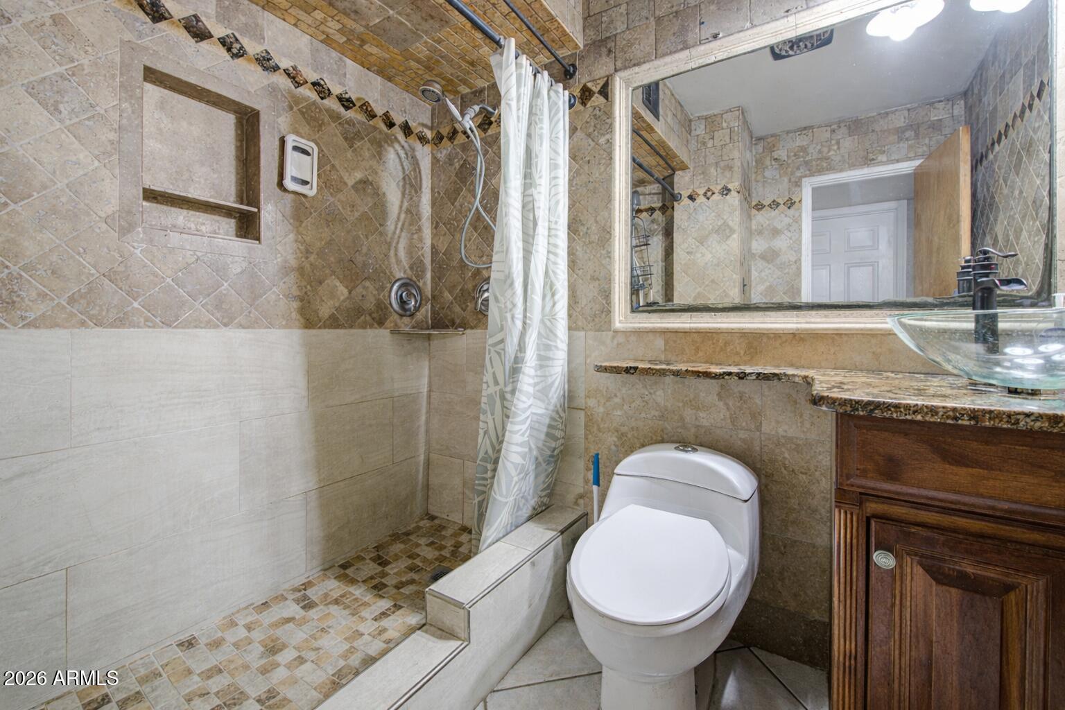 3107 West Montebello Avenue Phoenix, AZ 85017 - Photo 25 of 30 a bathroom with a granite countertop toilet sink and mirror
