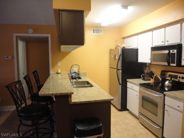 5307 Summerlin Road, Unit 710 Fort Myers, FL 33919 - Photo 1 of 19 a kitchen with stainless steel appliances a stove a sink a microwave a dining table and chairs