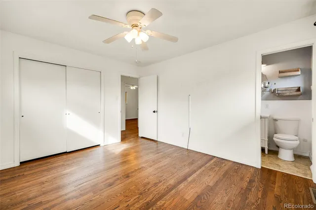 a view of a room with wooden floor and a ceiling fan