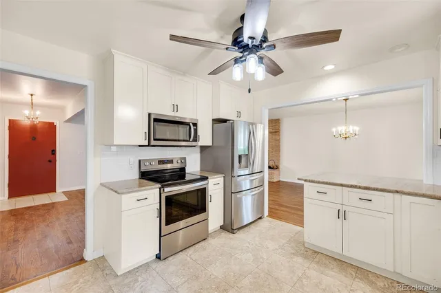 a kitchen with white cabinets and stainless steel appliances