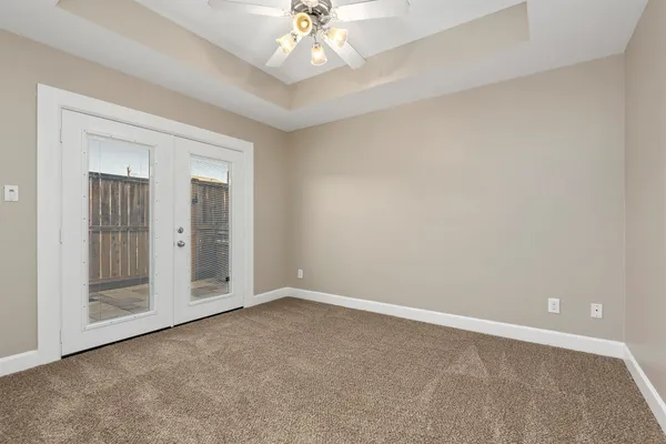 an empty room with chandelier fan