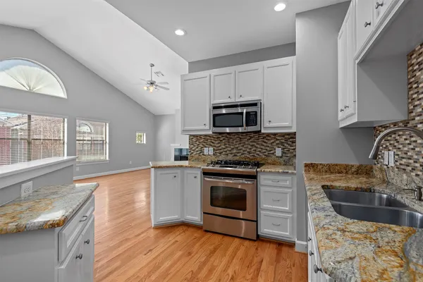 a kitchen with stainless steel appliances granite countertop a stove and a refrigerator
