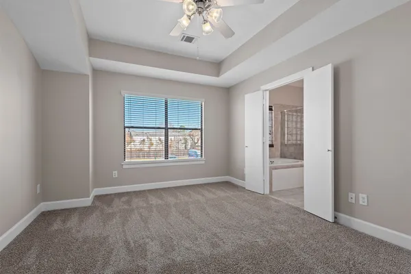 a view of an empty room with a ceiling fan and a window