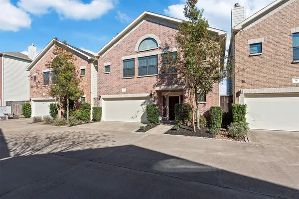 a view of a house with a yard and large tree