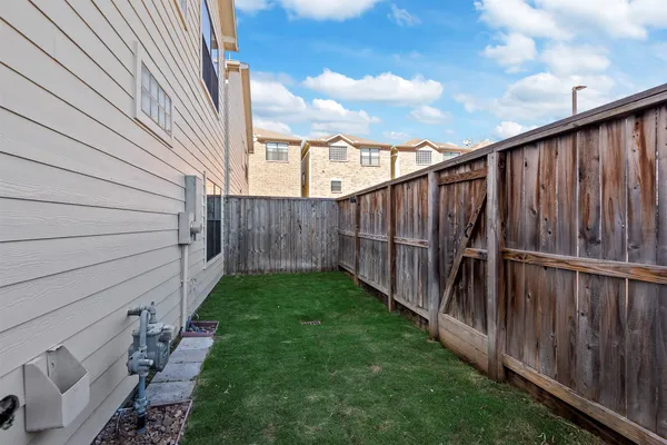 a view of a backyard with wooden fence