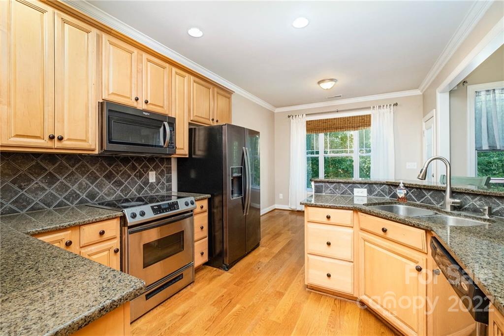 5712 Davis Road Waxhaw, NC 28173 - Photo 15 of 43 a kitchen with stainless steel appliances granite countertop a stove a sink and a microwave