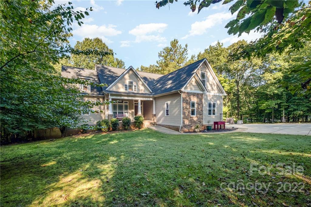 5712 Davis Road Waxhaw, NC 28173 - Photo 7 of 43 a front view of a house with a garden and trees