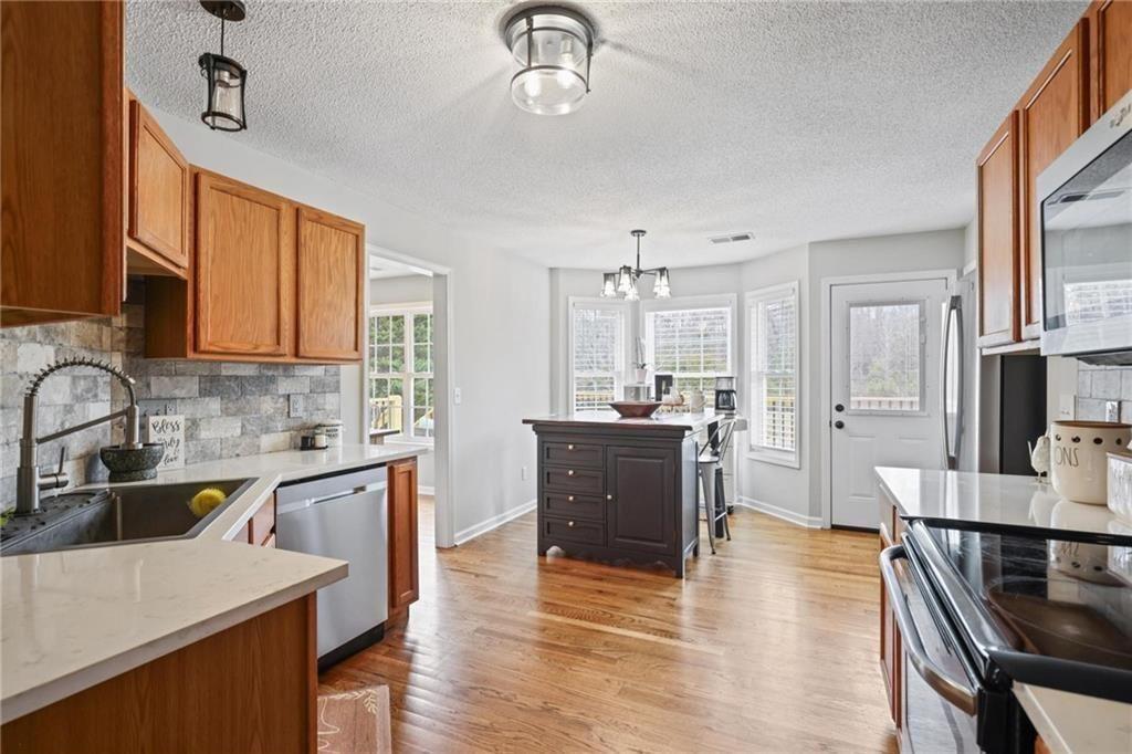 342 Miller Path Temple, GA 30179 - Photo 12 of 47 a kitchen with stainless steel appliances granite countertop wooden cabinets a dining table and chairs