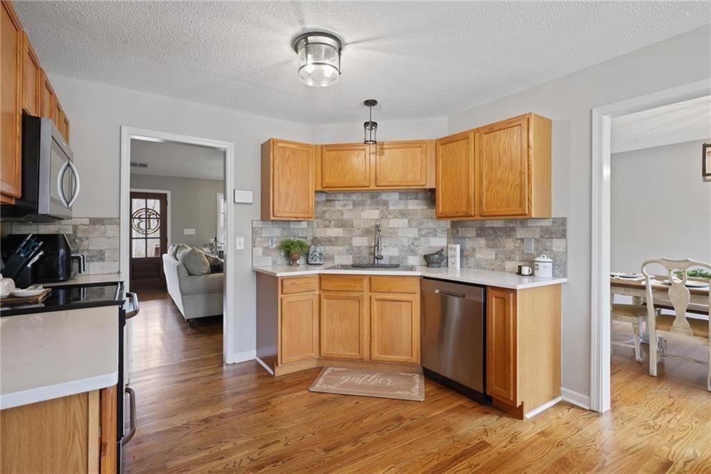 342 Miller Path Temple, GA 30179 - Photo 13 of 47 a kitchen with stainless steel appliances granite countertop wooden floors a stove and a microwave