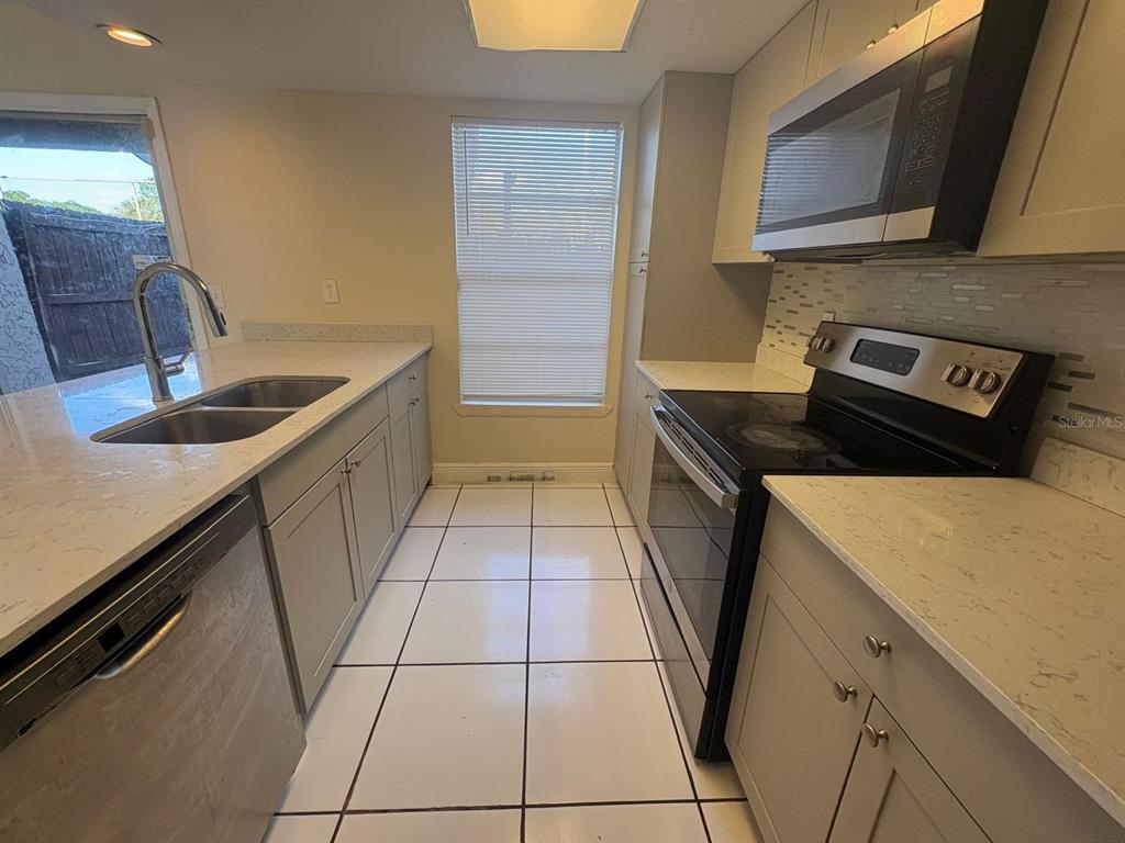 4033 Henley Road, Unit 1707 Orlando, FL 32839 - Photo 18 of 66 a kitchen with a sink stove and cabinets