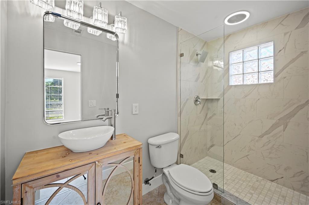3 Kings Road, Unit A7 Naples, FL 34112 - Photo 12 of 20 Full bath with healthy amount of natural light, vanity, and a marble finish shower
