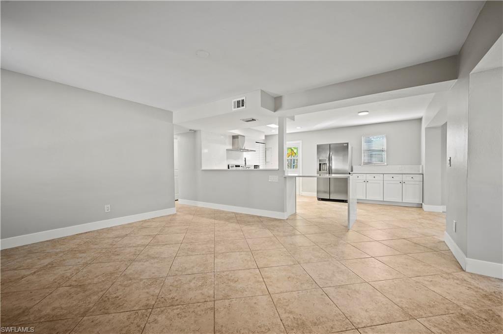 3 Kings Road, Unit A7 Naples, FL 34112 - Photo 3 of 20 Unfurnished living room with light tile patterned floors and baseboards