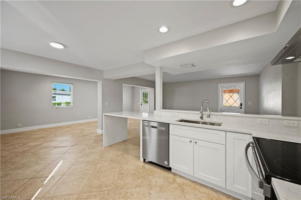 3 Kings Road, Unit A7 Naples, FL 34112 - Photo 7 of 20 Kitchen with stainless steel dishwasher, white cabinets, light stone counters, range with electric stovetop, and recessed lighting
