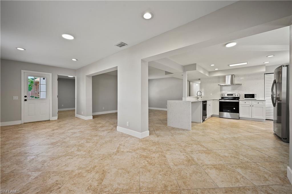 3 Kings Road, Unit A7 Naples, FL 34112 - Photo 20 of 20 Kitchen featuring open floor plan, appliances with stainless steel finishes, white cabinets, a peninsula, and recessed lighting