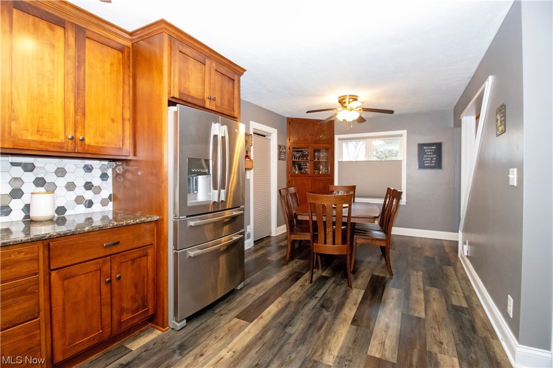 4464 Buss Road Wooster, OH 44691 - Photo 14 of 20 Kitchen featuring dark stone counters, ceiling fan, stainless steel refrigerator with ice dispenser, backsplash, and dark hardwood / wood-style floors