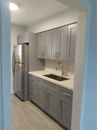 a kitchen with a sink and refrigerator