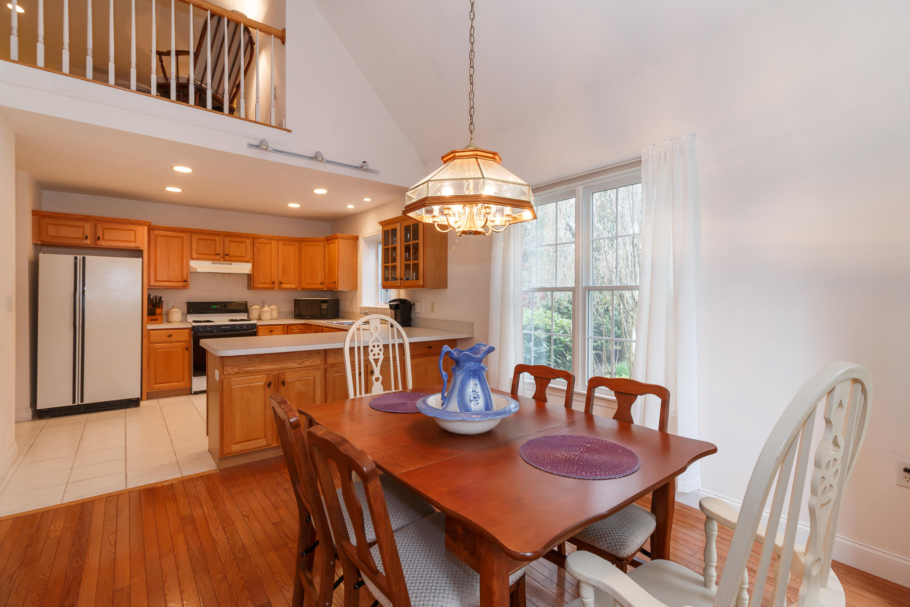 36 Windsor Point Mashpee, MA 02649 - Photo 12 of 23 a kitchen with stainless steel appliances granite countertop a stove a refrigerator a kitchen island a dining table and chairs with wooden floor