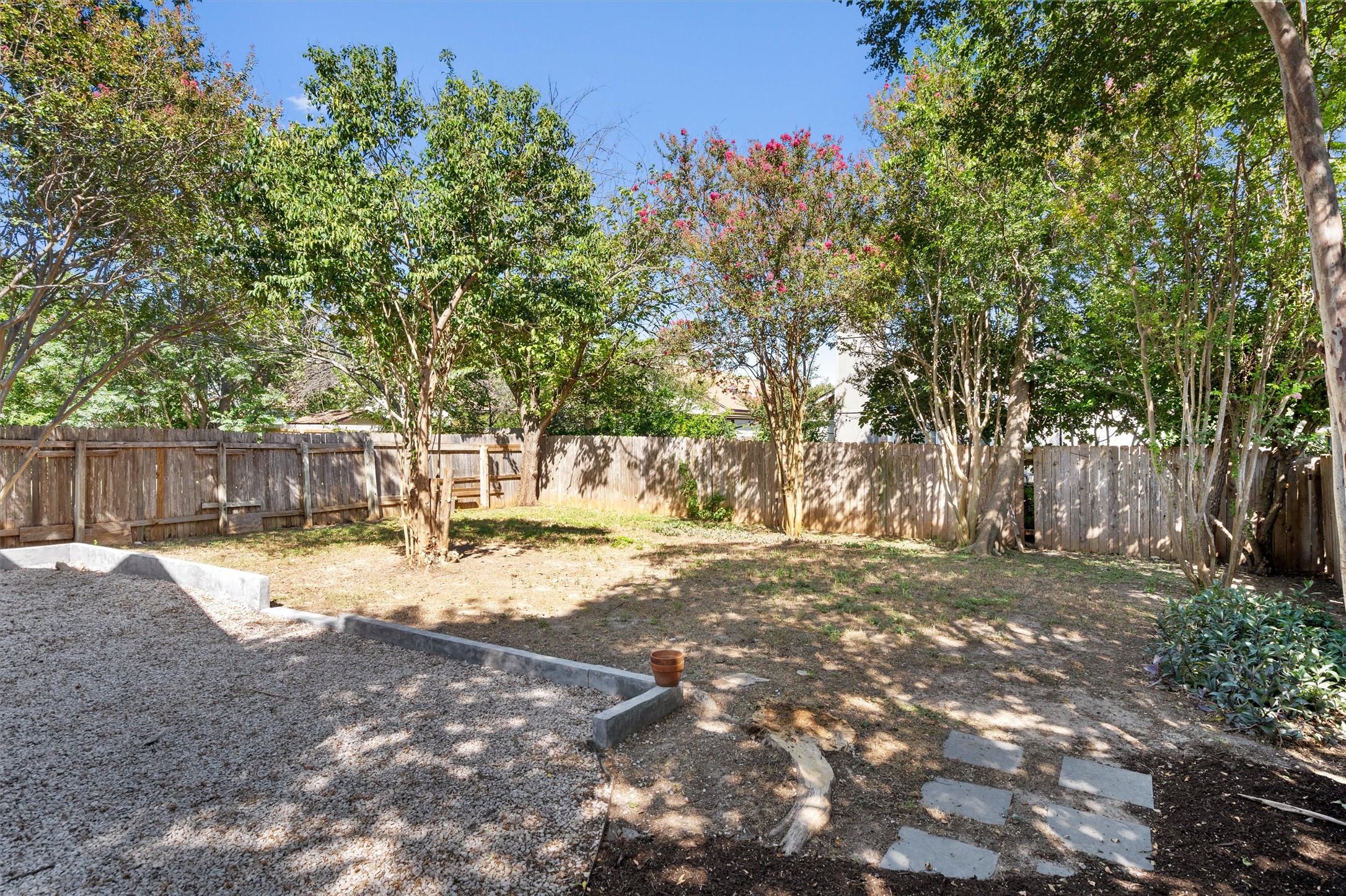 12321 Emery Oaks Road Austin, TX 78758 - Photo 26 of 27 A well-maintained, private backyard retreat with mature trees and a sturdy wood fence for peaceful outdoor living.