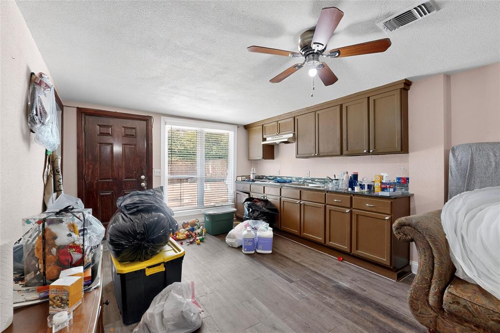 940 Rowlett Road Rowlett, TX 75088 - Photo 18 of 37 a kitchen with stainless steel appliances granite countertop a stove top oven a sink a dining table and chairs with wooden floor