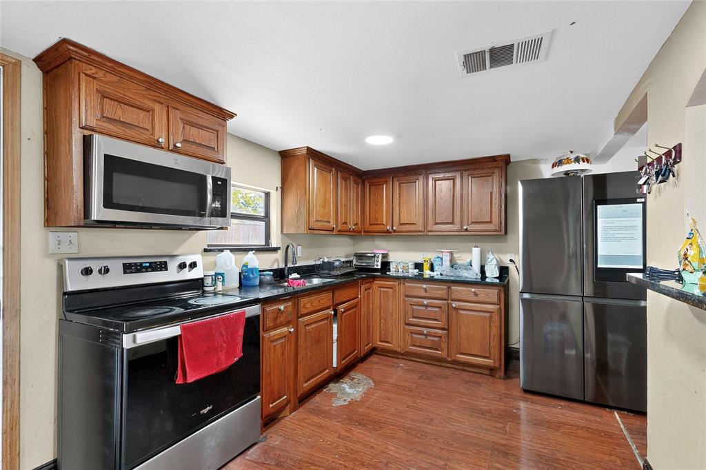 940 Rowlett Road Rowlett, TX 75088 - Photo 24 of 37 a kitchen with granite countertop a refrigerator stove top oven and sink