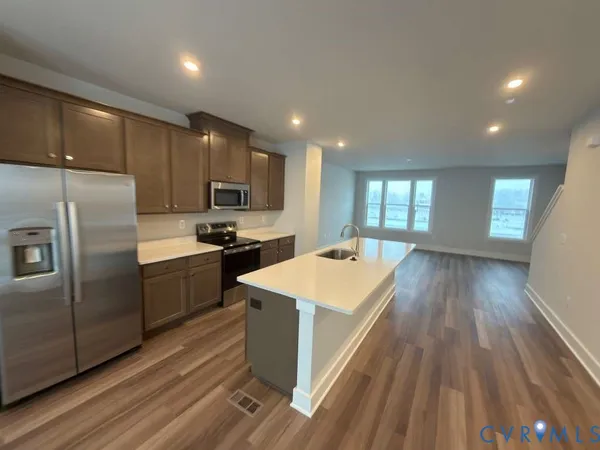 a view of a kitchen with furniture and wooden floor
