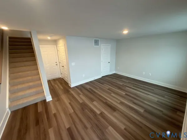 a view of a room with wooden floor and stairs