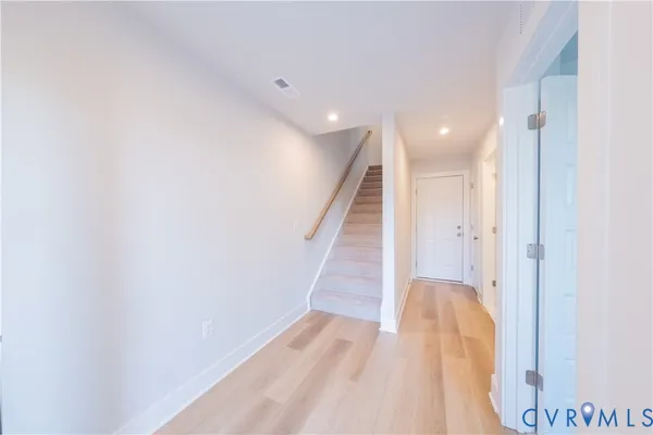 a view of a hallway with wooden floor and staircase