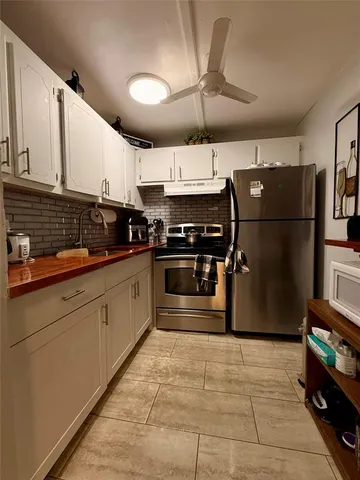 a kitchen with stainless steel appliances granite countertop a refrigerator a sink a stove and dishwasher