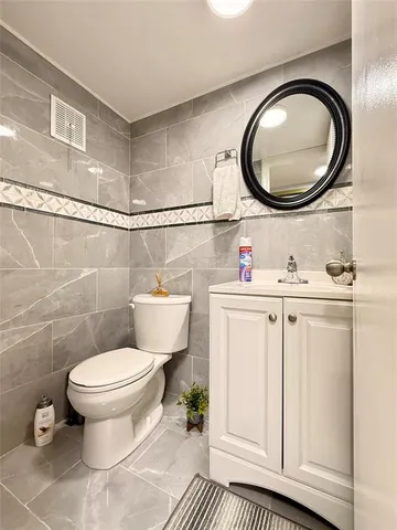 a bathroom with a toilet a sink and a mirror