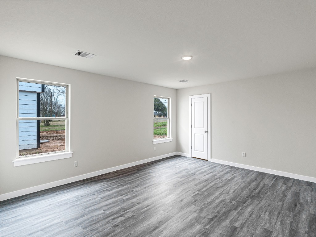 1010 4th Street Hempstead, TX 77445 - Photo 13 of 23 a view of an empty room with wooden floor and a window