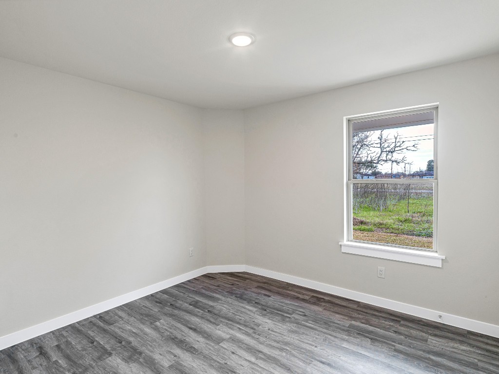 1010 4th Street Hempstead, TX 77445 - Photo 17 of 23 a view of an empty room with wooden floor and a window