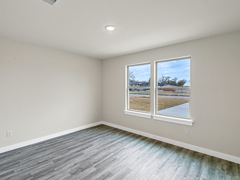 1010 4th Street Hempstead, TX 77445 - Photo 18 of 23 an empty room with wooden floor and windows