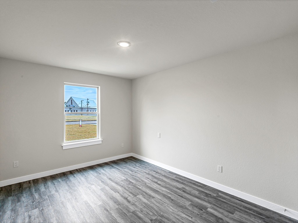 1010 4th Street Hempstead, TX 77445 - Photo 19 of 23 an empty room with wooden floor and windows