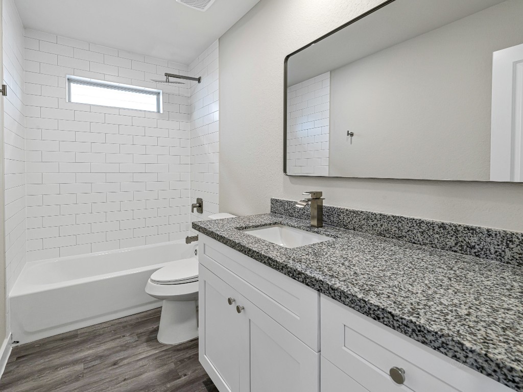 1010 4th Street Hempstead, TX 77445 - Photo 20 of 23 a bathroom with a granite countertop sink a toilet and bathtub