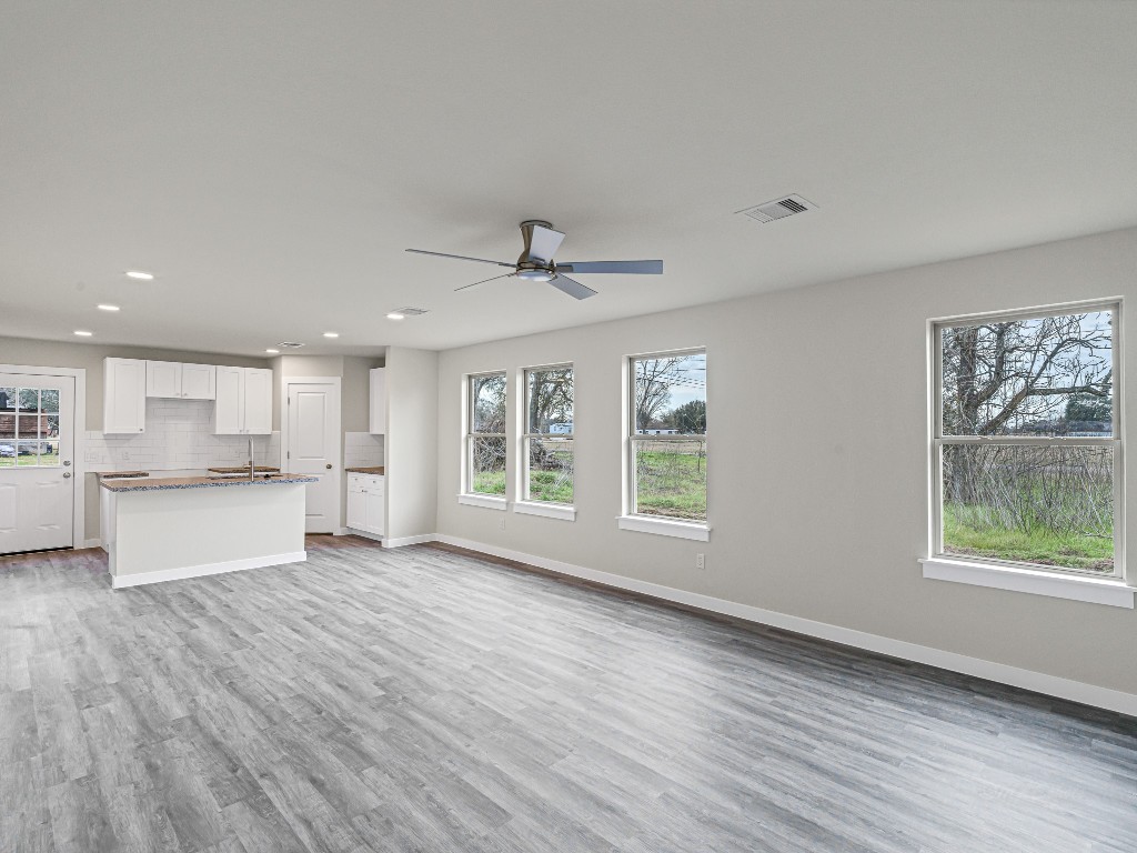 1010 4th Street Hempstead, TX 77445 - Photo 7 of 23 a view of an empty room with a window and wooden floor
